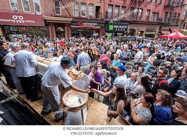 Workers from Ferrara Bakery and Cafe distribute cannolo pieces after their attempt to assemble the world's largest cannolo singular of cannoli at the 88th...