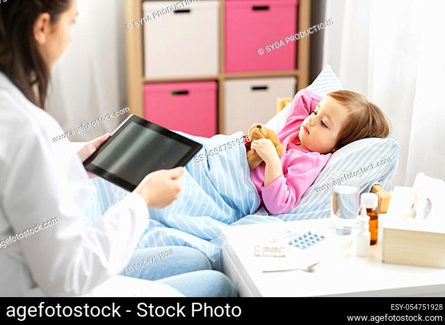 doctor with tablet computer and sick girl in bed