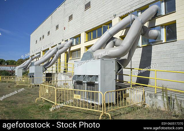 Temporary air conditioning machinery outdoors. Huge tubes are inserted from outside