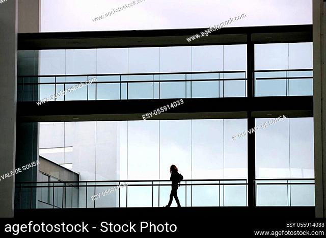 Silhouette view of young businesswoman in a modern office building interior with panoramic windows