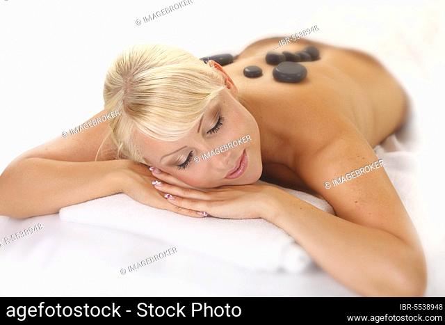 Woman doing hot stone massage, hot stones, basalt, LaStone therapy