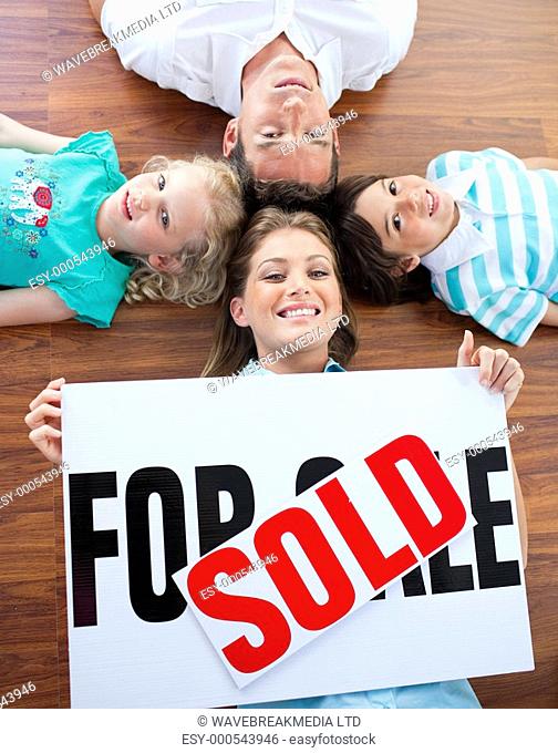 Happy family celebrating buying their new house lying on the floor