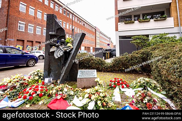 PRODUCTION - 23 November 2023, Schleswig-Holstein, Kiel: Flowers are laid at the Kiel Synagogue memorial, which stands on the site of the synagogue destroyed in...