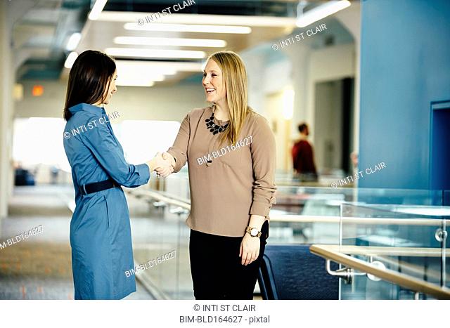 Caucasian businesswomen shaking hands in office