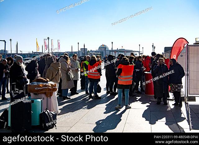 11 March 2022, Berlin: After arriving in Berlin, war refugees from Ukraine stand in front of a tent at the main train station