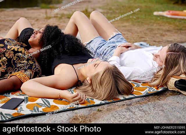 Three friends lying on blanket