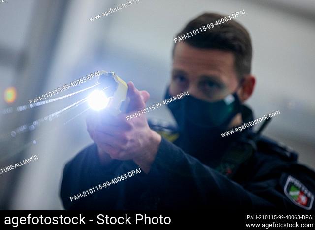 15 January 2021, North Rhine-Westphalia, Dortmund: A police officer demonstrates a shot with a distance electrical impulse device (DEIG or also Taser)