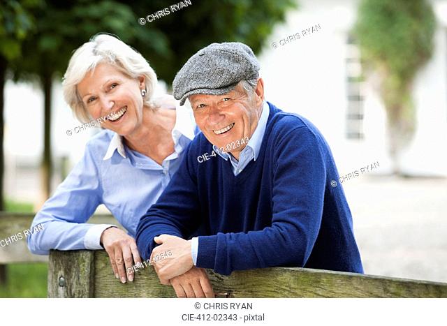 Couple smiling by wooden fence