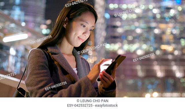 Business woman read on smart phone in city at night
