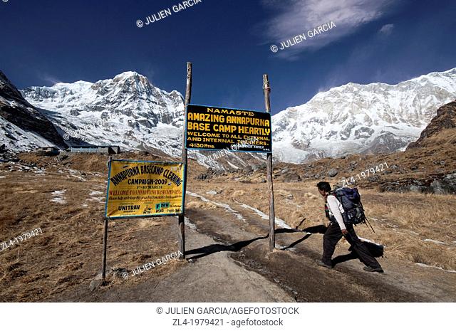 Nepali trekker reaching the Annapurna Base Camp at 4130m altitude. Nepal, Gandaki, Annapurna, Annapurna Base Camp
