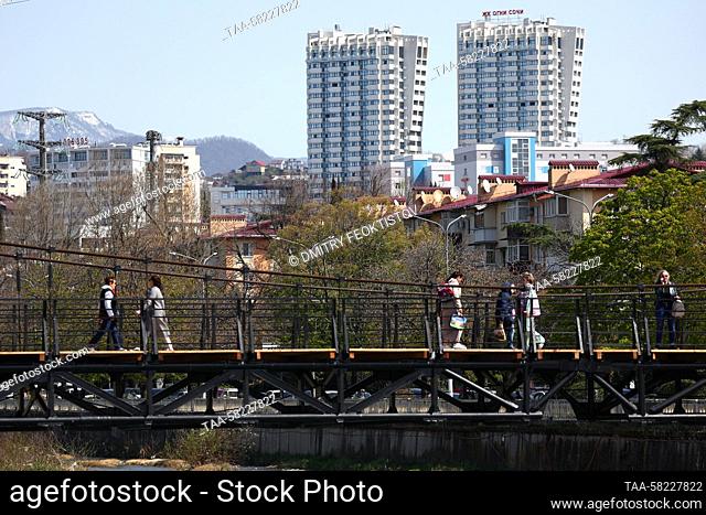 RUSSIA, SOCHI - APRIL 4, 2023: A view of a pedestrian bridge with tower blocks of the Ogni Sochi housing development behind in the seaside resort of Sochi