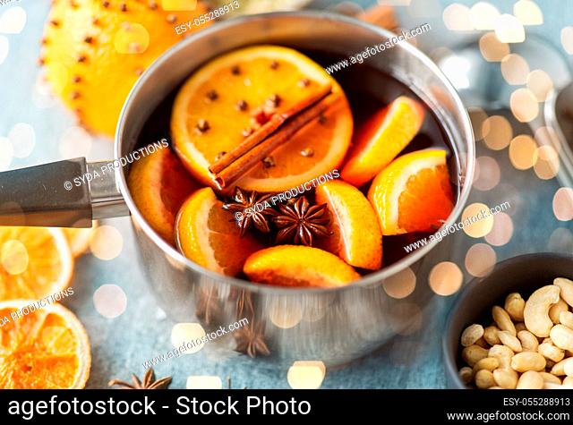 pot with hot mulled wine, orange slices and spices