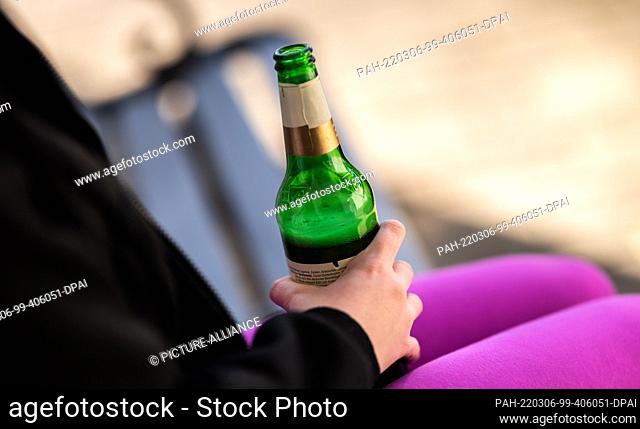 04 March 2022, Baden-Wuerttemberg, Rottweil: Illustration: A teenage girl holds a bottle of beer in front of her house. (To dpa ""DAK: Depressed kids abuse...