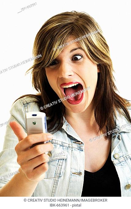 Young woman looking at her mobile phone, screaming
