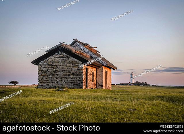 Sweden, Oland, Ottenby, Stone huts with Lange Jan lighthouse in distant background