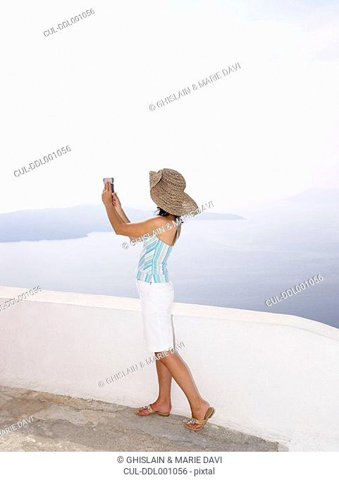 Woman taking a picture of the sea