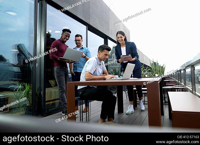 Business people working with laptops and digital tablet on balcony