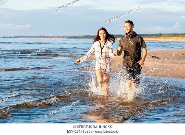 Summer, love. Attractive couple running on the beach
