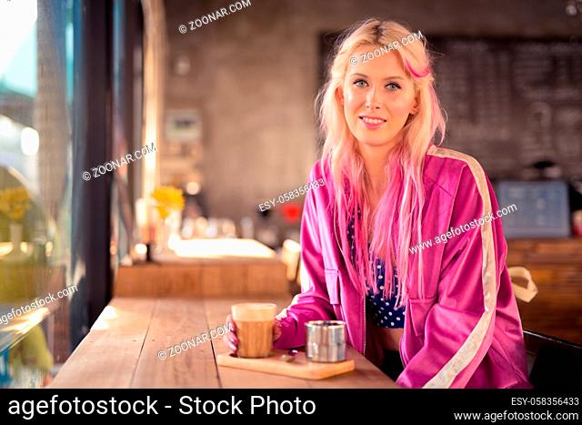 Portrait of young beautiful blonde woman relaxing at the coffee shop