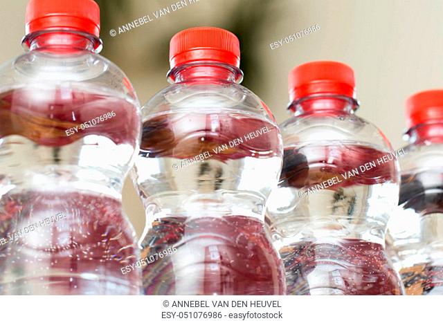 Row of water bottles, bubbling spa red, recycling environment concept close-up
