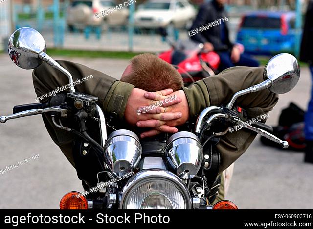 Motorcyclist resting on his bike at the opening of the summer season