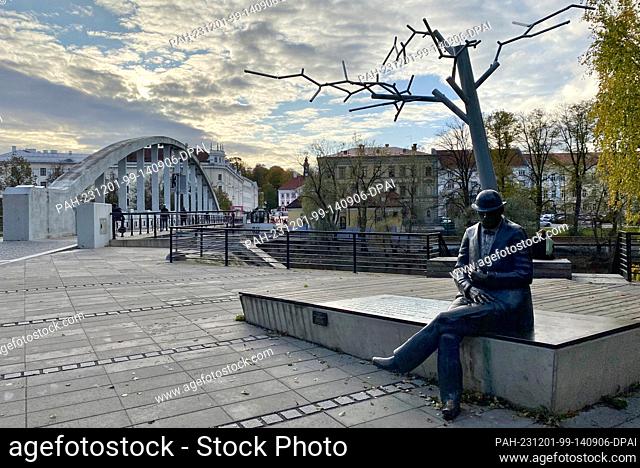 PRODUCTION - 20 October 2023, Estonia, Tartu: The monument to the Estonian journalist and poet Johann Voldemar Jannsen with the arched bridge in the background