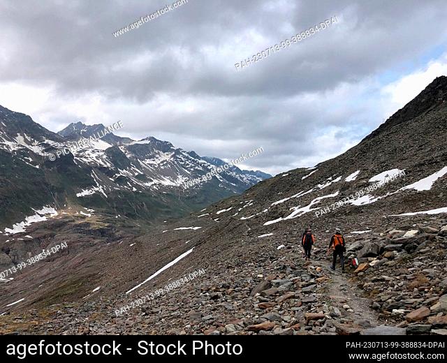 27 June 2023, Austria, Hochgurgl: Hikers walk through a moraine landscape in the Ötztal Alps near the Gurgler Ferner. The area was once glaciated
