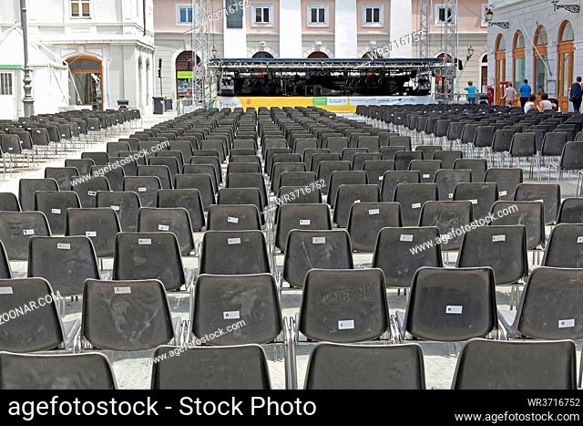 Trieste, Italy - July 15, 2013: Stage and Empty Plastic Chairs for Audience at Square in Trieste, Italy