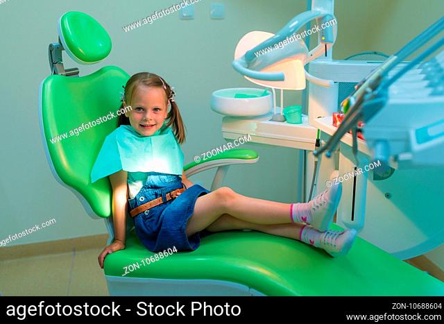 Healthy teeth patient girl waiting in dental chair in dentist office - dental caries prevention