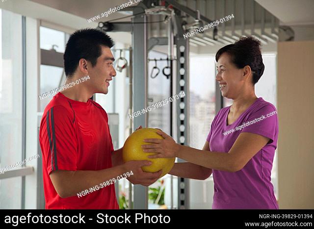 Mature woman exercising with her trainer