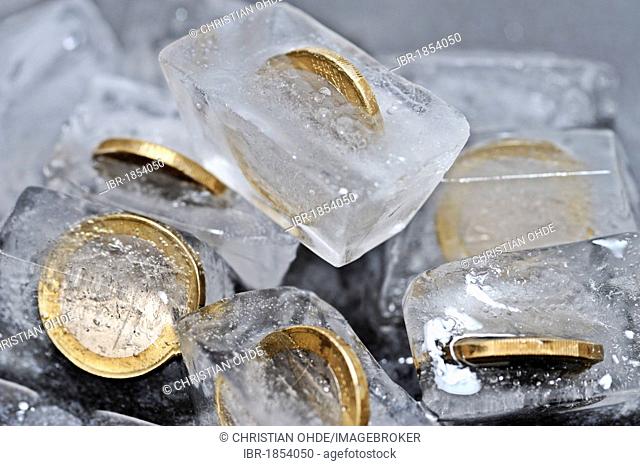 One-euro coins in ice cubes, symbolic image for frozen funds
