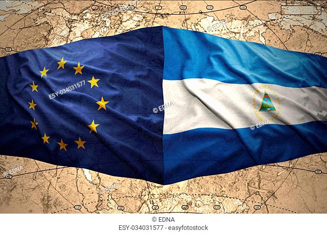 Waving Nicaraguan and European Union flags on the of the political map of the world