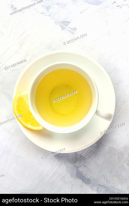A photo of a cup of green tea with lemon, shot from the top with copy space