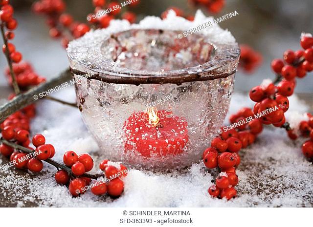 Ice bowl with candle and holly berries