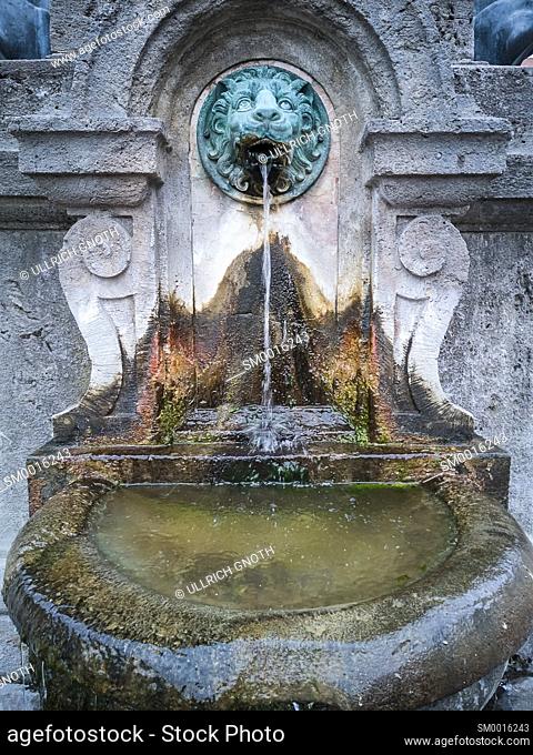 Fountain with lion face at the war memorial in Freising, Bavaria, Germany