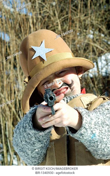 Boys, 5, dressed as a cowboy with a pistol for Carnival