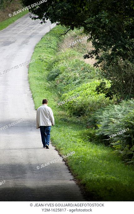 Lone man walking along a road Green, nature, solitude