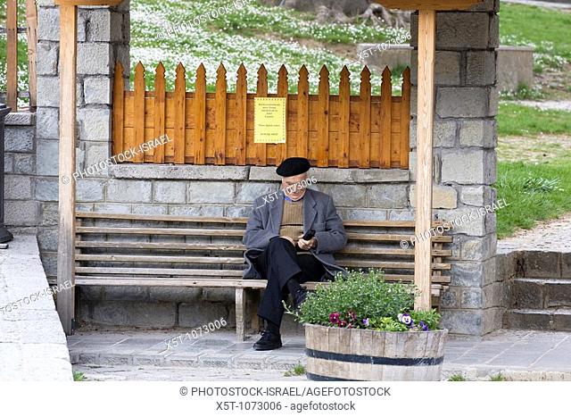 Greece, Epirus, Metsovo, Old men sitting on a bench at the square at the town's centre