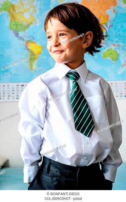 Portrait of boy in school uniform, World map in background