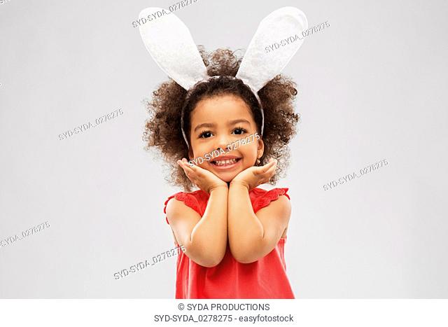 happy little girl wearing easter bunny ears posing