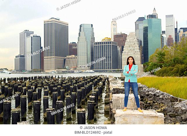 Mixed race woman smiling at urban waterfront, New York, New York, United States