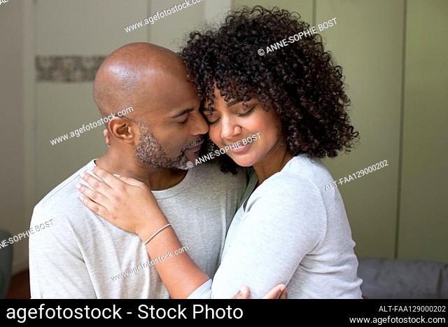 Couple romancing while sitting in bedroom