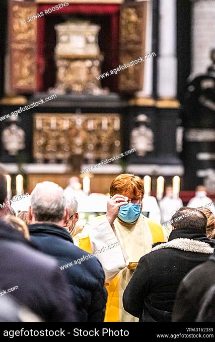An acolyte gives the communion during the celebration of the Midnight mass on Christmas eve at the 'Sint-Romboutskathedraal' Cathedral in Mechelen