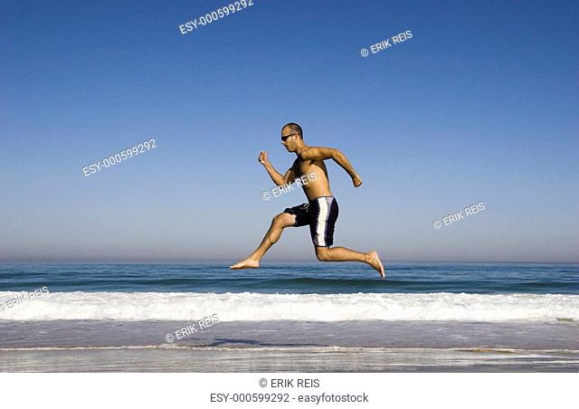 Man running and jumping on the beach