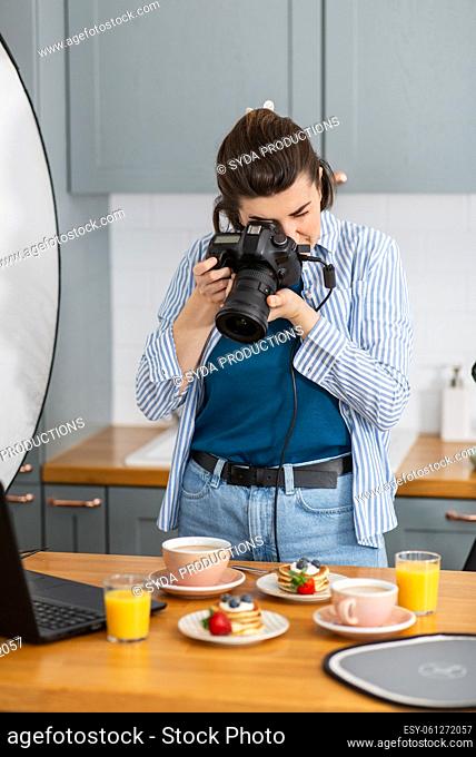 food photographer with camera working in kitchen