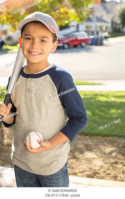 Portrait of smiling boy with baseball and bat