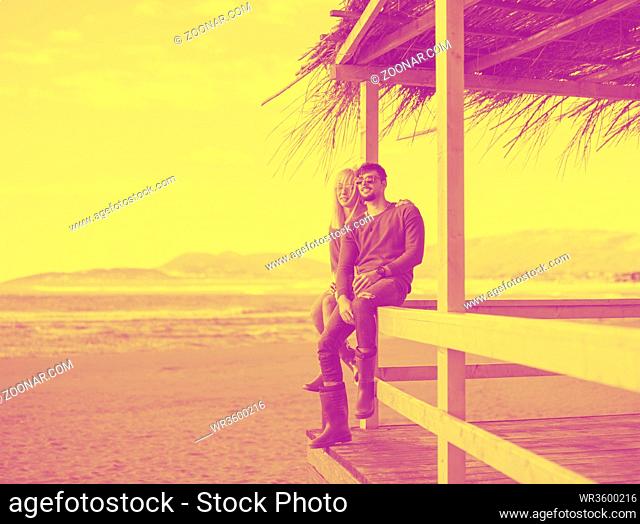 Couple Drinking Beer Together in empty beach bar during autumn time