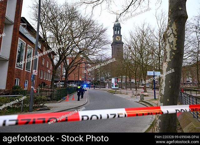 28 March 2022, Hamburg: Police officers stand in the early morning in the area around the discovery site, which has been widely cordoned off with flutter tape