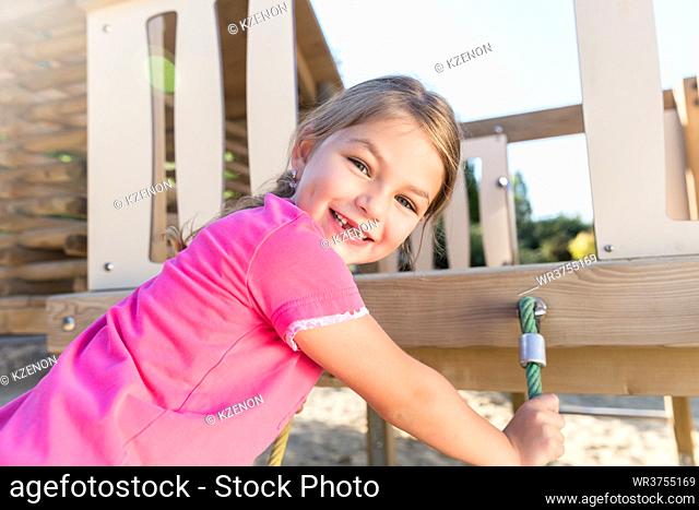 Little girl climbing on adventure playground already lost some teeth
