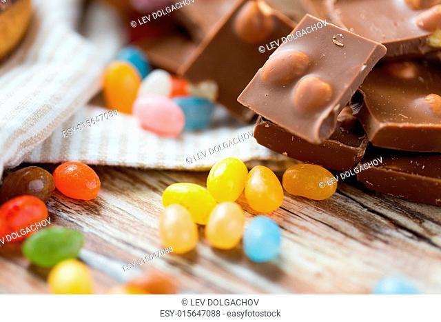 food, junk-food, culinary, baking and eating concept - close up of jelly beans candies and chocolate on table